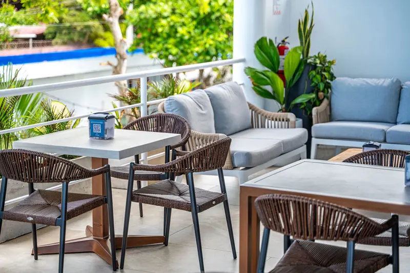 Terraza de Ozeano con sillas de ratán, mesas y sillones