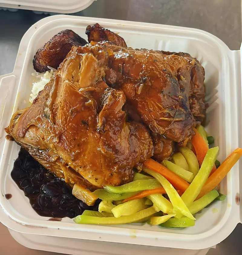 Pollo en salsa con frijoles y vegetales en un envase para llevar