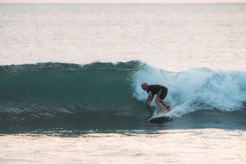 Surfista en la cara de una ola verde a punto de romper