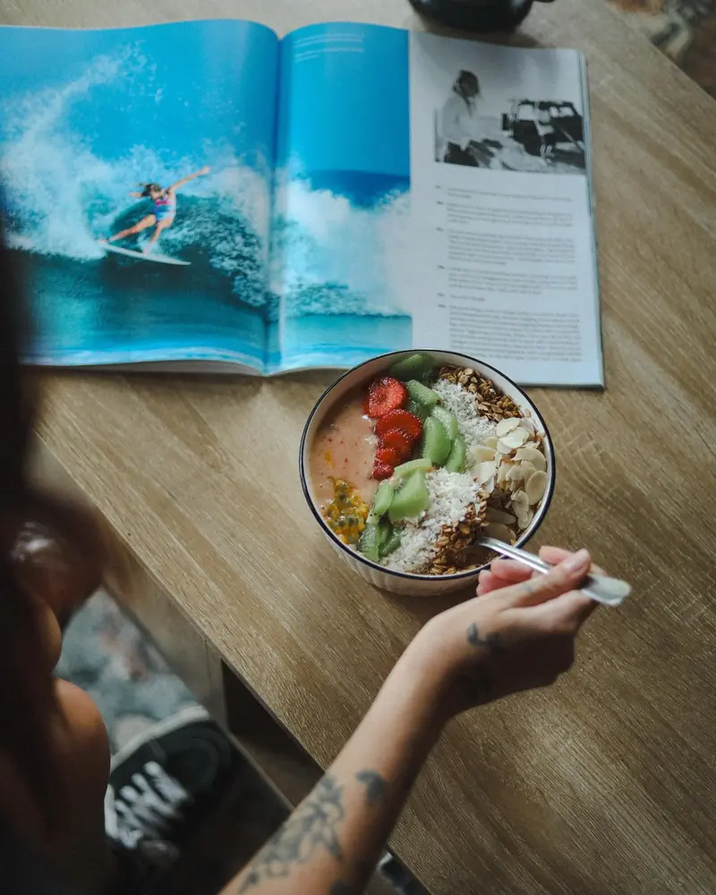 Bowl de ensalada visto desde arriba sobre una revista de surf abierta