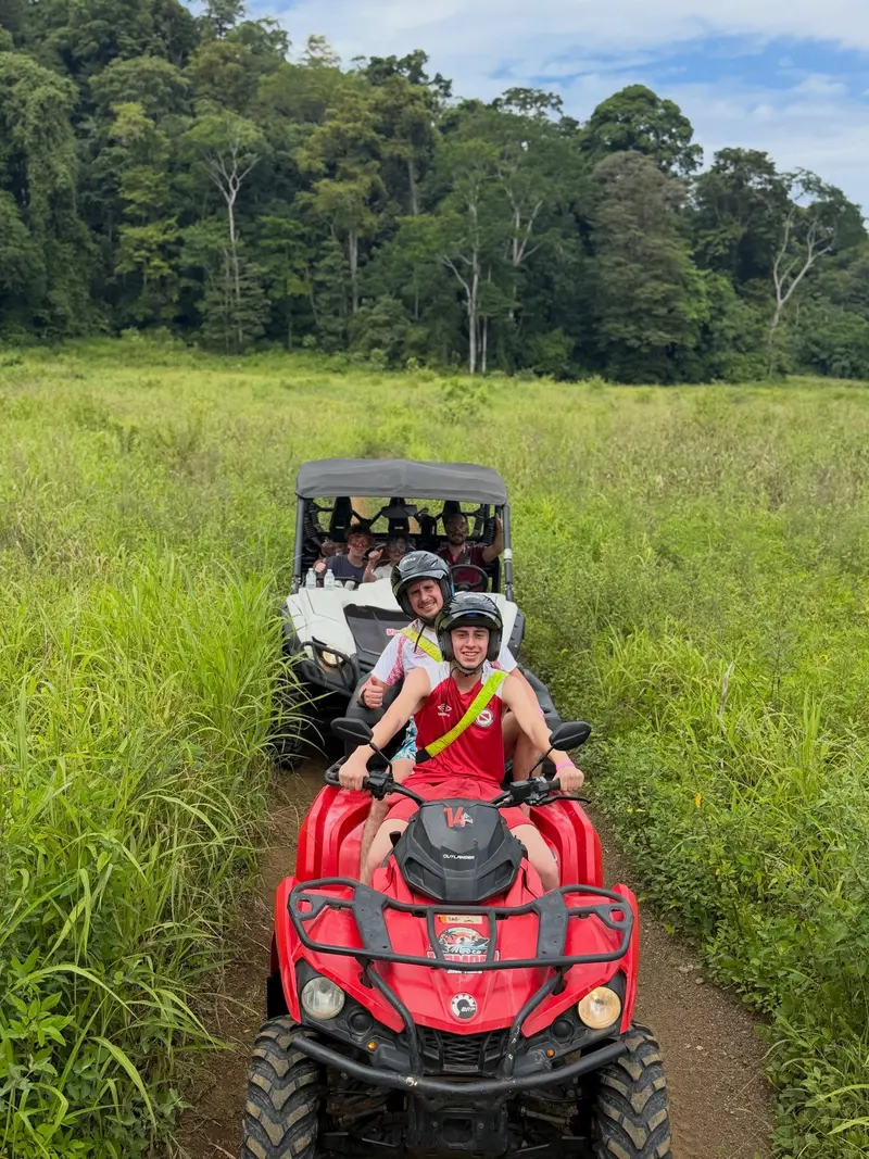 Cuatrimoto avanzando por un camino entre pastizales y bosque