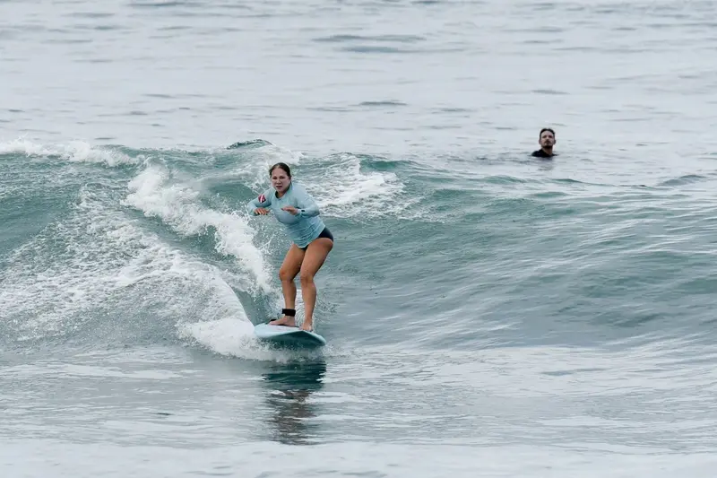 Surfer standing on a board on a small wave