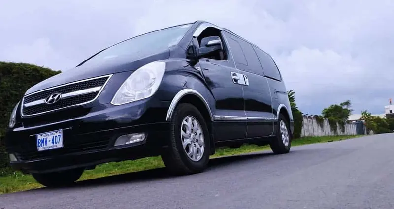 Van negra de transporte de Roosterfish Rentals estacionada en la calle