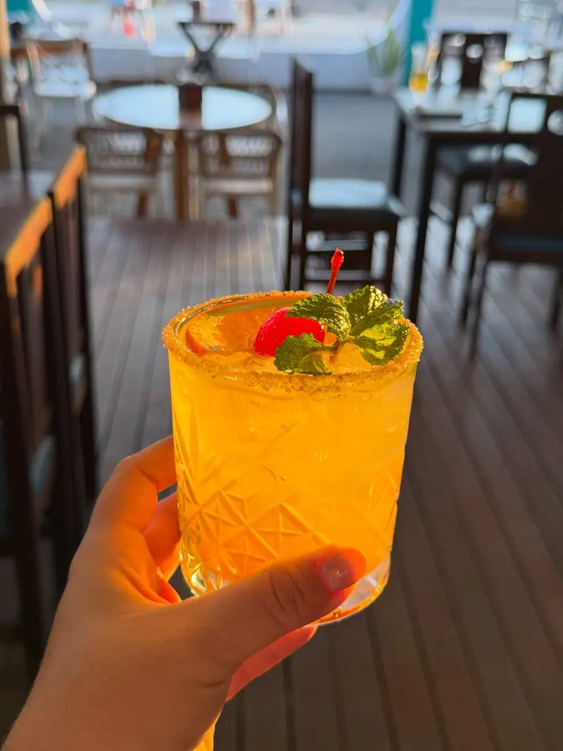 Cóctel anaranjado con cereza en la terraza de KoKo