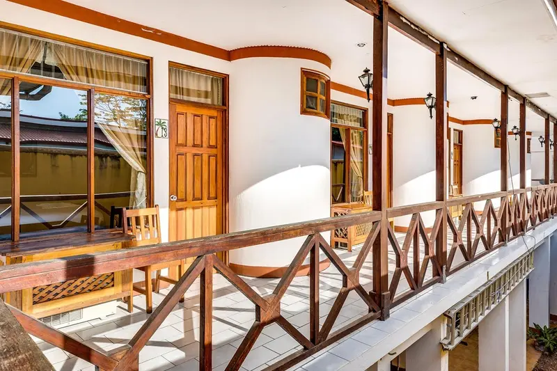 Corredor con barandas de madera frente a las puertas de las habitaciones