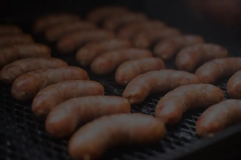 Salchichas dorándose sobre una parrilla