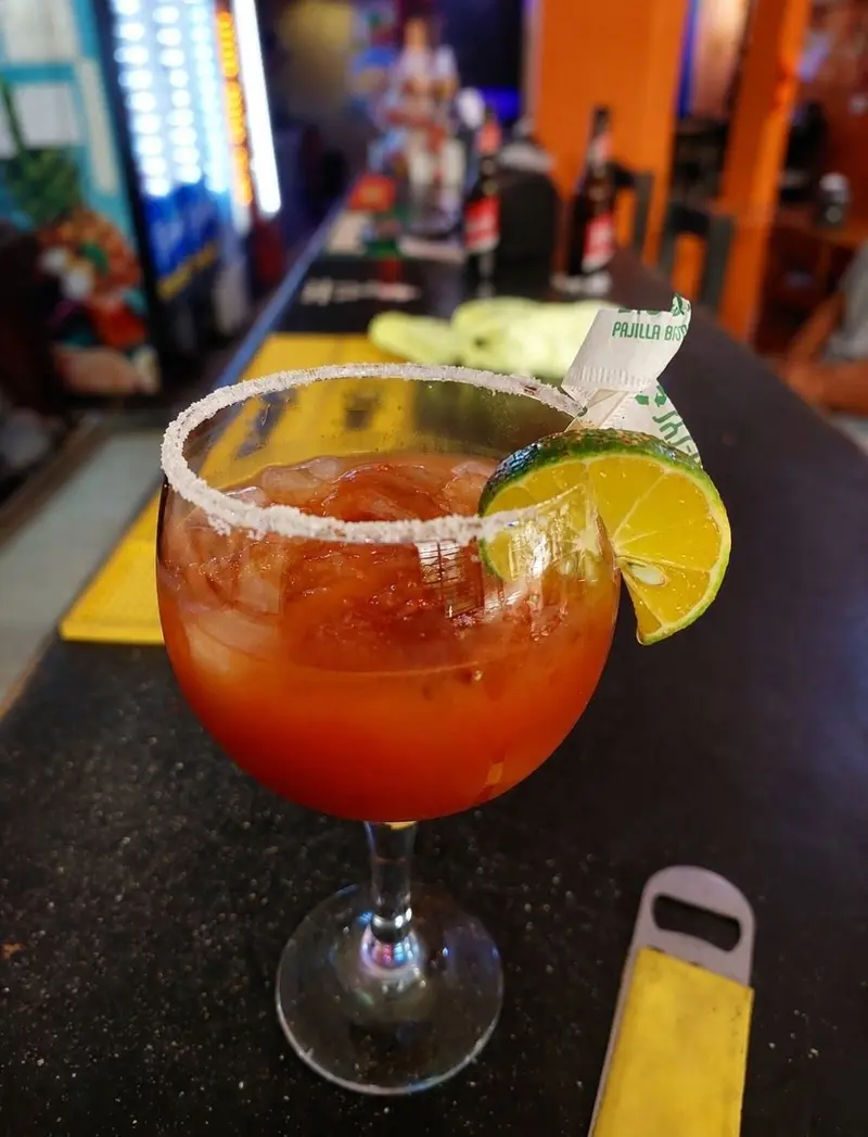 Michelada en copa escarchada con limón sobre la barra del restaurante