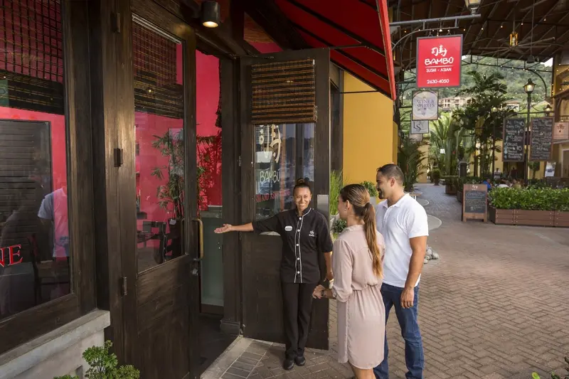 Anfitrión recibiendo a una pareja en la entrada de Bambú