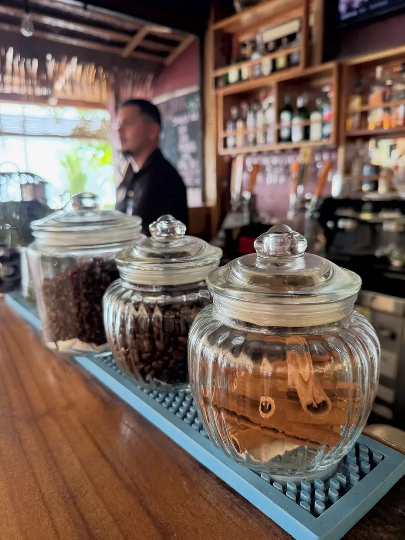 Jars of coffee beans and cinnamon sticks lined up on the Vida Hermosa bar